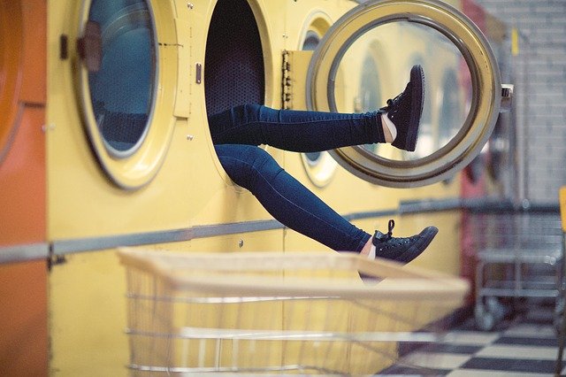 pieds de femmes qui dépassent d'une machine à laver